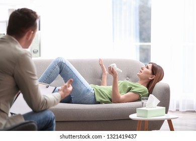 Psychotherapist working with woman in light office