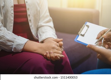 Psychotherapist works and counsels young woman, closeup on hands, toned.