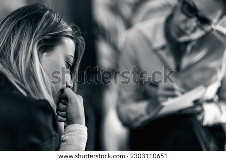 Psychotherapy office. Troubled woman talking to psychotherapist about her problems 