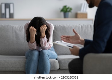 Psychotherapy, treatment of depression concept. Stressed woman having session at psychologist's office, closing face and crying, receiving professional help in solving personal problems