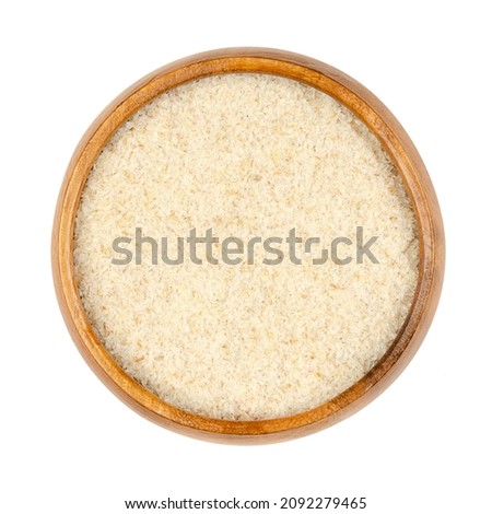 Psyllium seed husk in a wooden bowl. Ground seeds of plantago ovata, also blond plantain, desert Indianwheat, blond psyllium and ispagol. Common source of psyllium, a dietary fiber and food thickener.