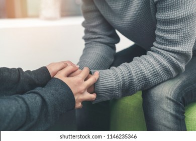 PTSD Mental Health Concept, Psychologist Sitting And Touch Hand Young Depressed Asian Man For Encouragement Near Window, Selective Focus.