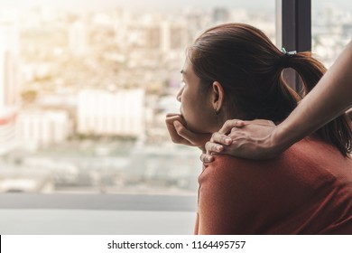 PTSD Mental Health Concept, Psychologist Sitting And Touch Young Depressed Asian Woman For Encouragement Near Window With Low Light Environment.Selective Focus.