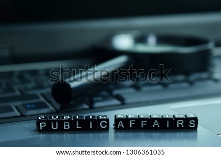 Public Affairs text wooden blocks in laptop background. Business and technology concept