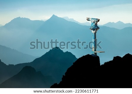 Public binoculars and Mountain Silhouettes at Sunrise. Concept for foresight and vision for new business solutions and creative ideas. Alps, Allgau, Bavaria, Germany.
