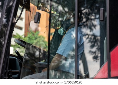 Public Bus Driver With Mask Waiting For The Traffic Light Change In The City Of Bogota. April 12, 2020.