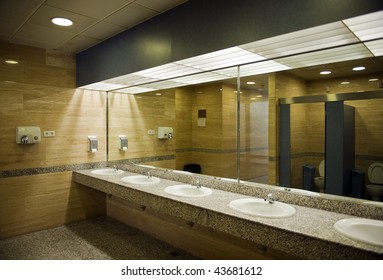 Public Empty Restroom With Washstands, And Toilets In Mirror