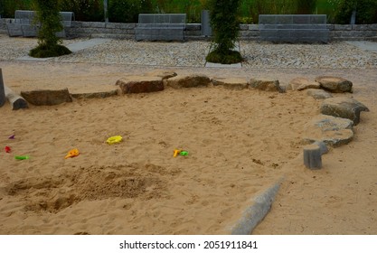 Public Multifunctional Playground With A Sandy Impact Zone And A Stainless Steel Slide In The Park With A Sandpit, A And A Rope Ladder For The Children's 