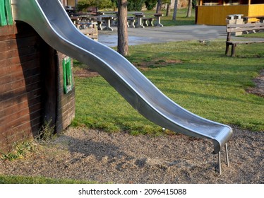 Public Multifunctional Playground With A Sandy Impact Zone And A Stainless Steel Slide In The Park With A Sandpit, A And A Rope Ladder For The Children's 