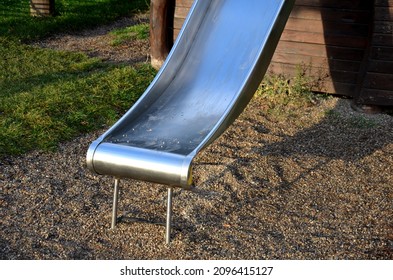 Public Multifunctional Playground With A Sandy Impact Zone And A Stainless Steel Slide In The Park With A Sandpit, A And A Rope Ladder For The Children's 