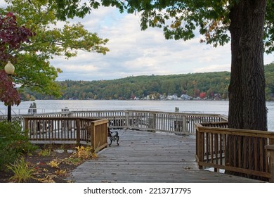 Public park lake overlook at the old Alton Bay Boston and Maine railroad depot. Boardwalk railing park benches, early autumn color in tree line on opposite bank.  - Shutterstock ID 2213717795
