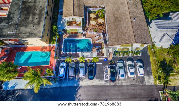 Public\
parking with homes and pool, aerial overhead\
view.