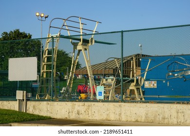 Public Pool And Diving Board Seen Though Fence