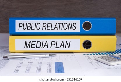 Public Relations And Media Plan - Blue And Yellow Binder On Desk In The Office