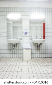 In An Public Restroom Hangs On An Wall Of An White Sink