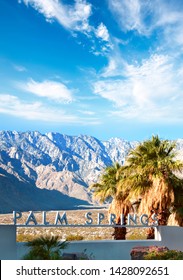 Public Sign On The Outskirts Of Palm Springs California With Palm Trees And Mountains In The Background.