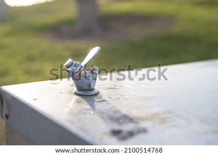 public, social use metal faucet with drinking water on street in park. Thirsty people drink in hot season in summer.  Strong stream of water. close up