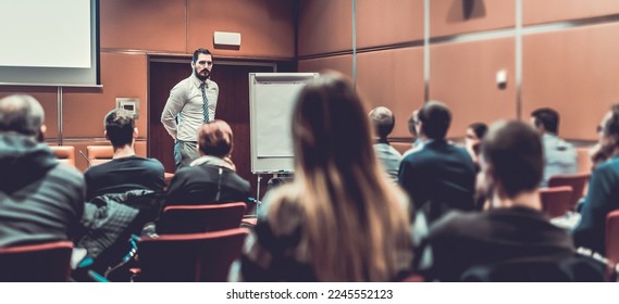 Public Speaker Giving a Talk at Business Meeting. Audience in the conference hall. Skilled coach answers questions of participants of business training. Business and Entrepreneurship concept. - Shutterstock ID 2245552123