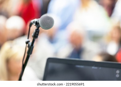 Public Speaking Event Concept, Microphone In The Focus, Blurred People In The Background