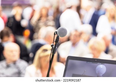 Public Speaking Event Concept, Microphone In The Focus, Blurred People In The Background