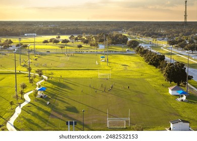 Public sports arena in North Port, Florida with school kids playing soccer game on grass football stadium. Outdoor activities concept - Powered by Shutterstock