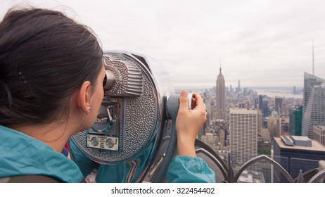 public telescope pointed on Manhattan buildings