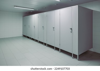 Public toilet cubicles. Clean toilet, view from inside the room. Closed cubicle doors in a public restroom
