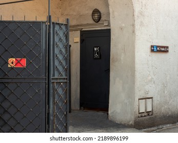 Public toilet door with wheelchair sign reserved for the disabled. Next to it an iron screen with the no-entry sign due to work in progress