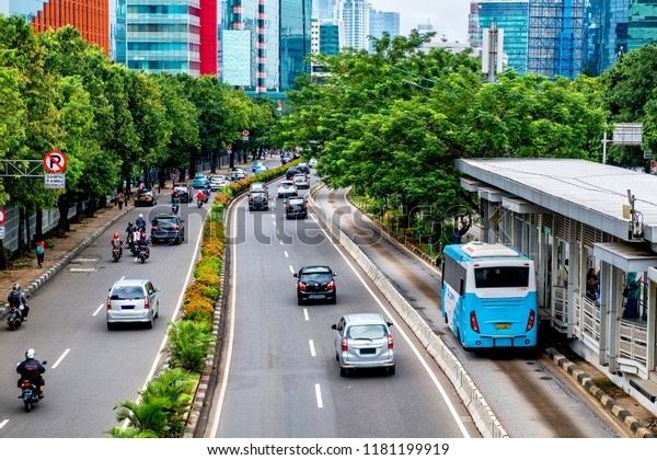 Public transport\
bus stopped in bus stop, waiting until passenger get in, in busy\
street at Jakarta,\
Indonesia.