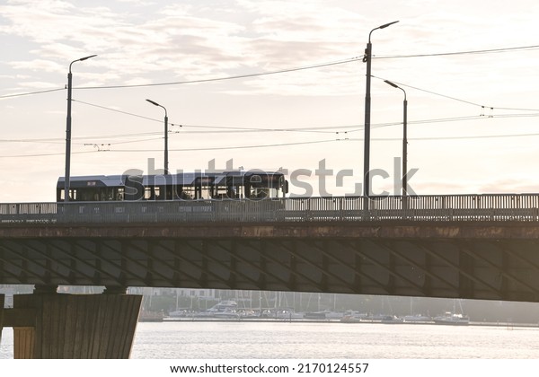 Public\
transportation bus in sunset light on Vansu Bridge from Riga.\
Transportation industry in Latvia,\
2022.