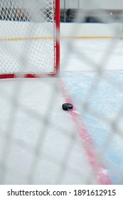 Puck Lying On Red Line Dividing Play Space And Zone Of Net On The Rink For Playing Hockey On Modern Stadium With Nobody On Tribune