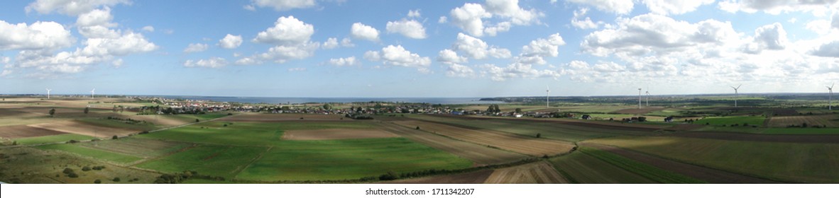 Pucka Bay panoramic picture taken from the top of windmill - water Bay, green field and blue sky with clouds - Shutterstock ID 1711342207