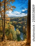 Puckoriu atodanga in Vilnius, Lithuania, is encircled by a vibrant autumn forest in Pavilniai Regional Park, bursting with green, yellow, and orange colors