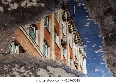 Puddle reflection of house wall 