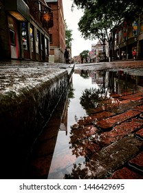 Puddle Reflects In Downtown Boston After A Summer Rain Shower