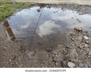 A puddle is a small pool of water. Puddle forms after rain, on roads or ground. Puddle reflects light beautifully. Stepping into a puddle can be fun! Its, a simple joy in nature's design. - Powered by Shutterstock