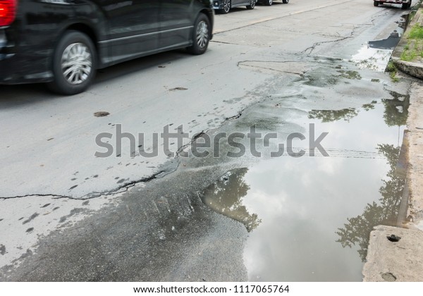 Puddle Water on the Crack road, flooded and road,\
Asphalt road cracks 