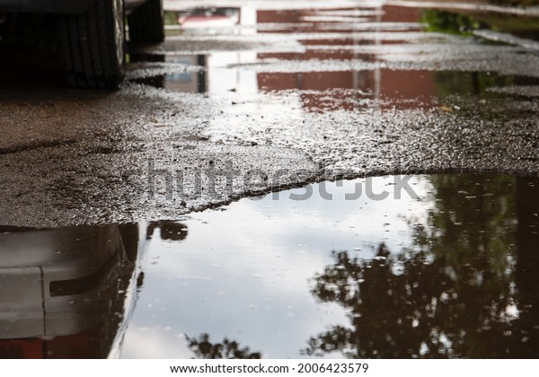 Puddles\
and water. Street, road with pits. City and\
cars.