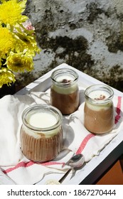 Puding Coklat Or Chocolate Pudding Or Panna Cotta In Sunny Day As Outdoor Meal With Yellow Flowers In The Table