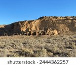 Pueblo Bonito, the largest and best-known great house in Chaco Culture National Historical Park in New Mexico. Chaco Canyon was a major Ancestral Puebloan culture center. Threatening Rock, canyon wall