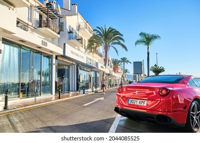 Puerto Banus, Marbella September 19, 2021, Luxury cars (Red Ferrrari) Yachts, luxury shops and restaurants in an exclusive place on the Costa del Sol