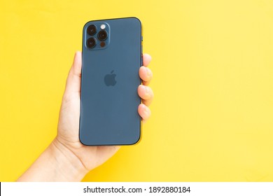 Puerto Cruz, Spain - January 12, 2020: Hand Holding IPhone 12pro, Back Side On Bright Yellow Background