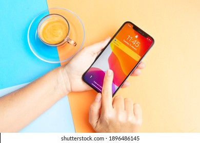 Puerto Cruz, Spain - January 12, 2020: Two Hands Holding New IPhone 12pro With Coffee On Bright Background