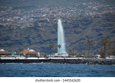 Puerto De La Cruz, Tenerife - April 12, 2017: View Of The Townscape And The Coastline On A Sunny Day. Fountains Of Lago Martianez - Famous Place For Tourists And Local People. Long Focus Lens Shot.