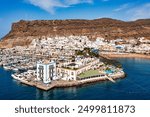 Puerto de Mogan with the beach in Gran Canaria, Spain. Favorite vacation place for tourists and locals on island. Harbor in Puerto de Mogan and Playa Mogan on Grand Canary Island, Spain.