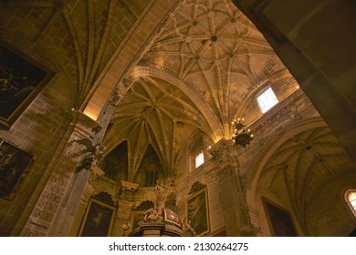 Puerto De Santa María, Spain - Feb. 25, 2022: Intricate Linear Ceiling Decoration In The Gothic Rib And Barrel Vault Ensemble Of Iglesia Mayor Prioral Church Above Sculptures Atop The High Altar