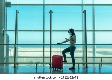 PUERTO DEL ROSARIO, FUERTEVENTURA, SPAIN - February 4, 2021: young woman with mask, wait for your flight at the empty terminal and with safety distance - selective focus


