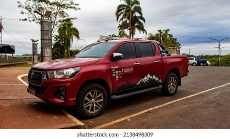 Puerto Iguazú, Misiones, Argentina. 01-29-2022: Red Pickup Truck With Snowy Mountains Stickers For Long Car Trip.