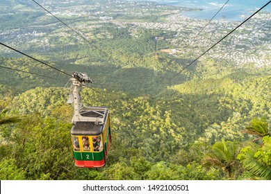 PUERTO PLATA/DOMINICAN REPUBLIC- DECEMBER 30, 2018: Cable car cabin in Loma Isabel de Torres mountain, with green mountain, Puerto Plata city and blue Caribbean sea in the background.