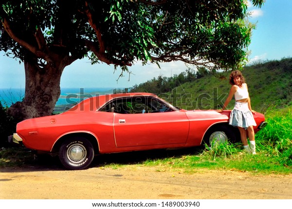 Puerto Rico, Ceiba, 1974 Dodge Challenger,\
Deborah Fletcher with a classic muscle car under a Mango tree\
overlooking the Caribbean Sea, April 20,\
1994